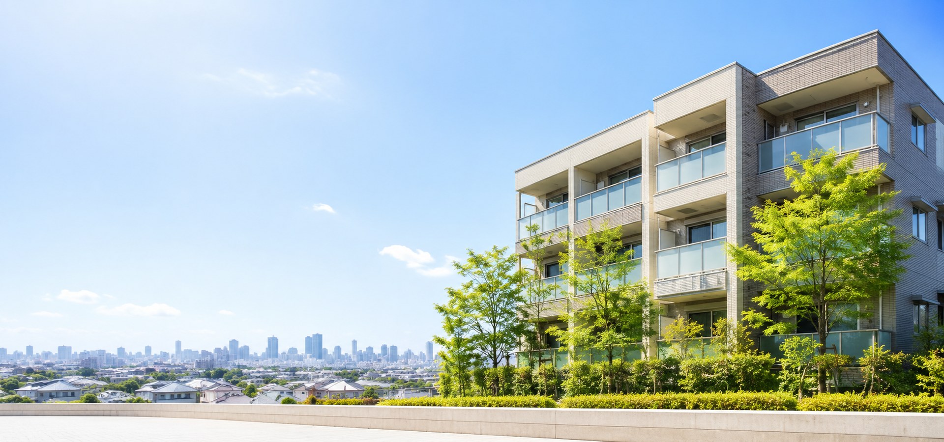 青空と3階建てマンション。東京・埼玉・千葉・神奈川の外壁塗装とアパート・マンション共用部修繕