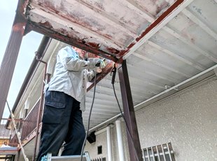 鉄骨階段の横桁を高所で補修しているようす