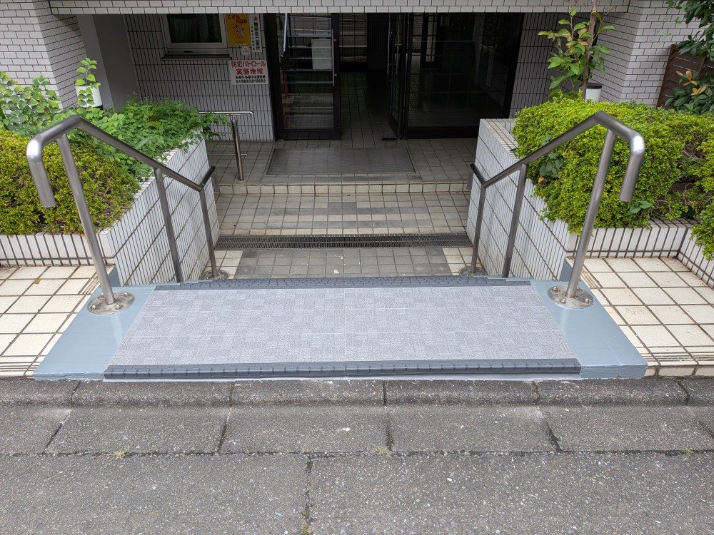 施工後:長尺シートで一新したマンションのエントランス入口全景