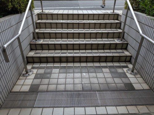 施工前：すり減りとタイル浮きが見られた既存タイル張りの共用階段