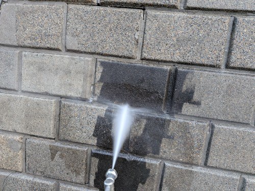 高圧洗浄の水を擁壁の壁面に当てているところ
